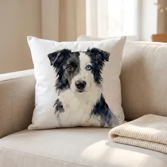 Square white throw pillow with a watercolor dog portrait on a linen sofa beside a knit blanket
